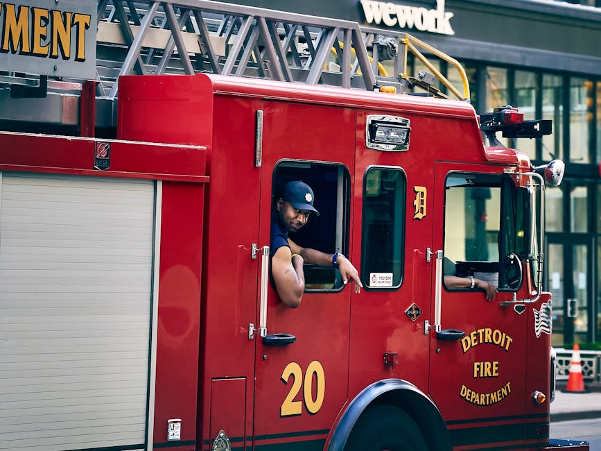 Detroit Fire Department firefighter leaning out of an apparatus cab window in turnouts
