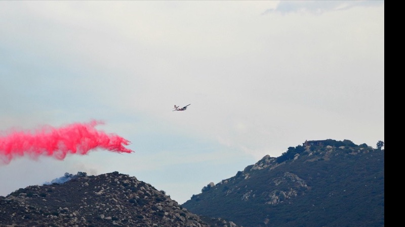 Wildfire air tanker dropping retardant over California hillside