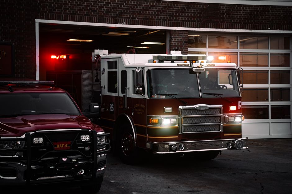 Fire truck responding from station at night with lights flashing