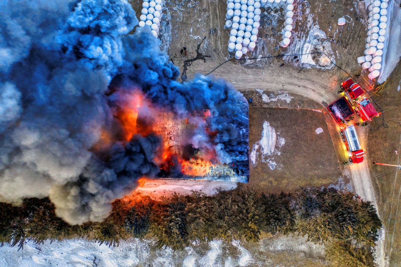 Aerial drone view of a structure fire with heavy smoke and fire apparatus on scene