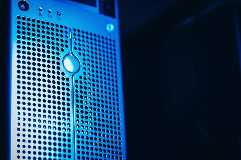 Close-up of a server tower with blue lighting and ventilation ports, symbolizing critical IT infrastructure under cybersecurity threat