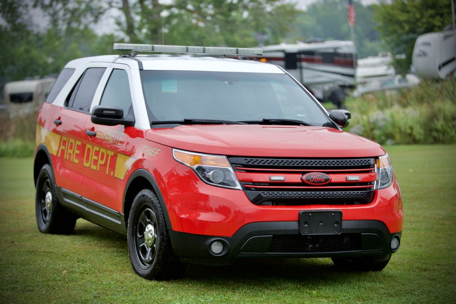 A red Ford Explorer fire department vehicle parked outdoors, marked with CHIEF and Fire Dept livery