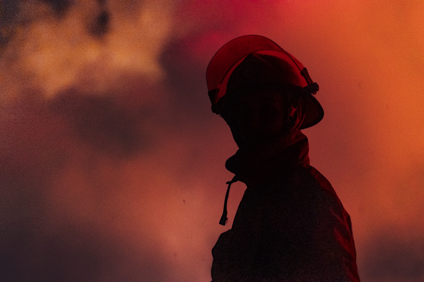 Firefighter silhouette in doorway of a smoke-filled room facing early flashover conditions