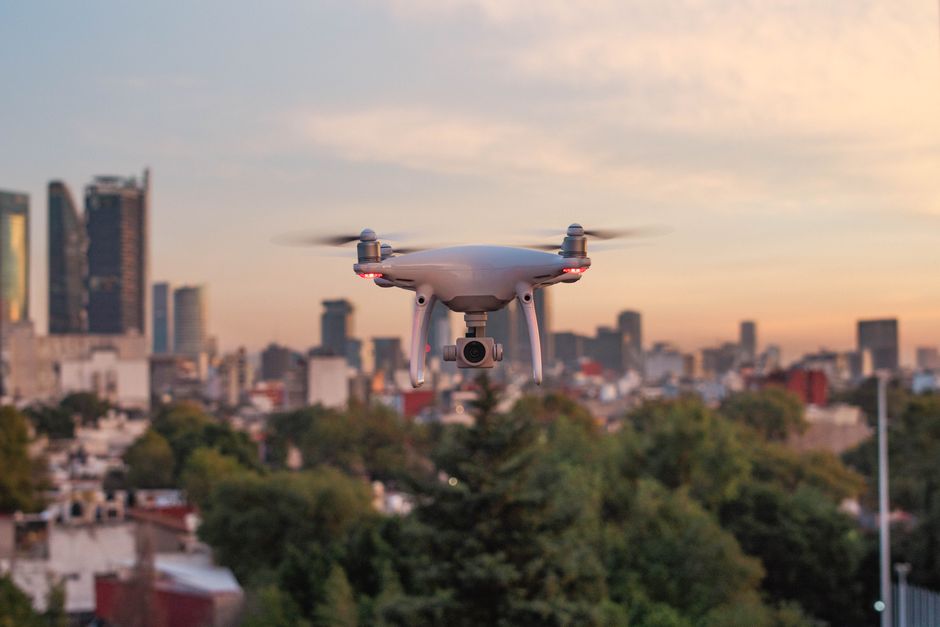 Drone flying over a cityscape at sunset representing FAA public safety drone waiver expansion