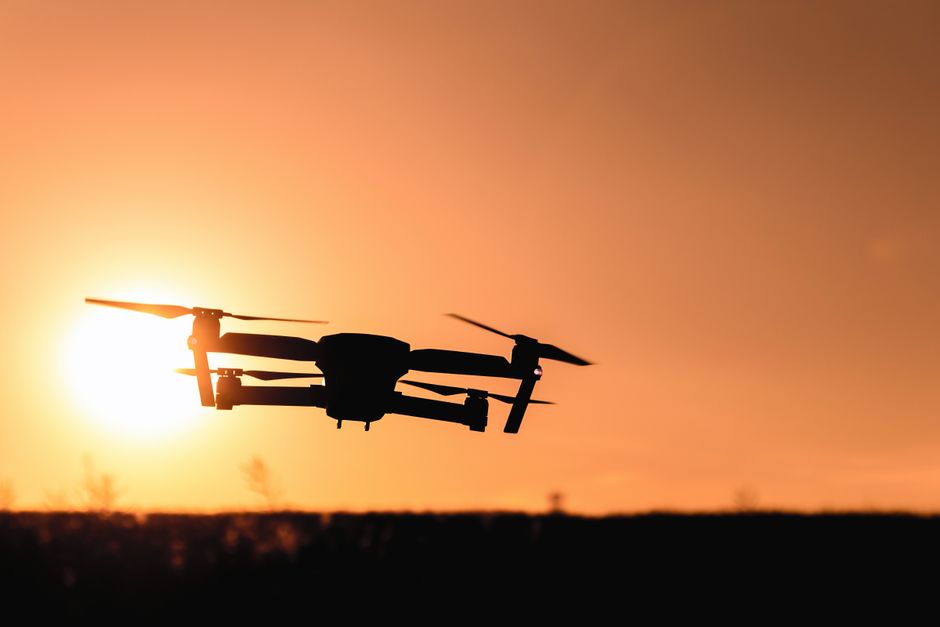 Quadcopter drone hovering against a clear sky