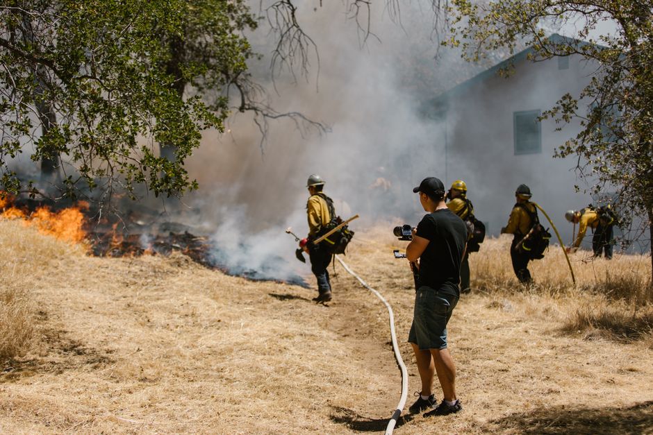 Firefighters combating a spreading wildfire near a home
