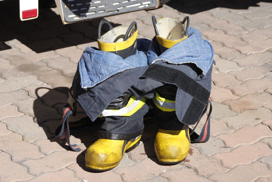 Close-up of firefighter turnout gear and boots on pavement