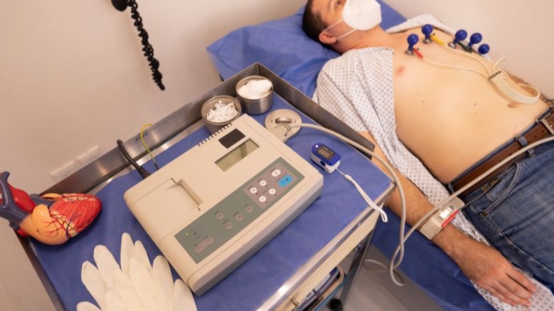 Firefighter undergoing a cardiac screening with ECG leads in a clinic