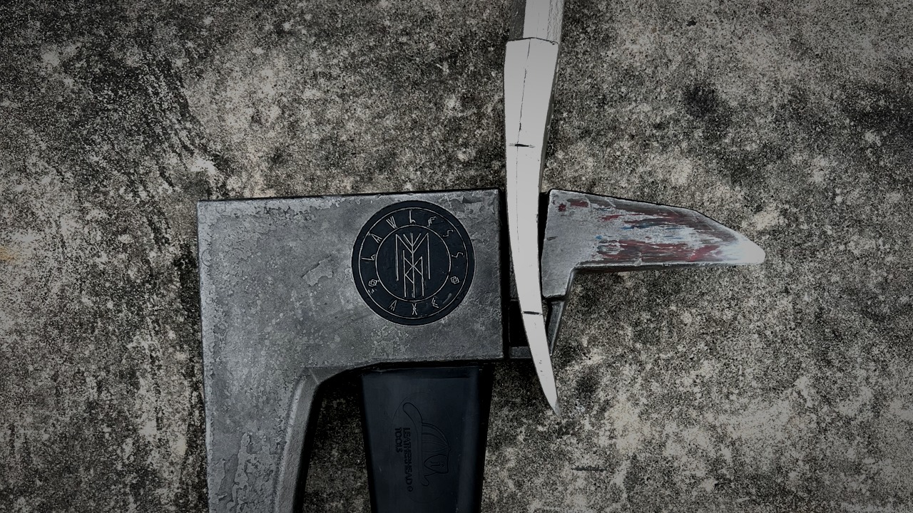 Close-up of the Lawless Axe joined with a Halligan on a textured surface